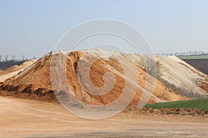 Clay mining. Waste soil hill and quarry road.
