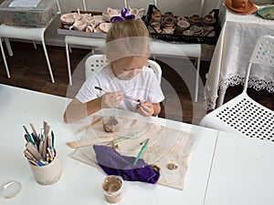 Clay modeling workshop. Kid girl sculpts from clay in pottery workshop. Education for child creative activities in Arts.