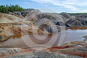 Clay mountains on the shore of the orange lake. Ural  refractory clay quarries