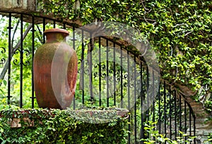 Clay pitcher pot and metal bars in colonial mexican garden photo