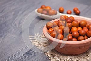 A clay plate with fresh ziziphus on wooden background