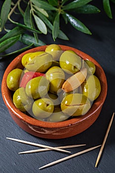 Clay pot with artisan olives preserved in extra virgin olive oil, vinegar, spices with red peppers and garlic.