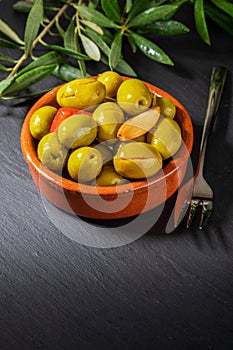 Clay pot with artisan olives preserved in extra virgin olive oil, vinegar, spices with red peppers and garlic.