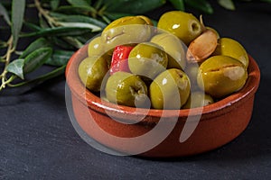 Clay pot with artisan olives preserved in extra virgin olive oil, vinegar, spices with red peppers and garlic.