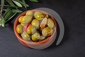 Clay pot with artisan olives preserved in extra virgin olive oil, vinegar, spices with red peppers and garlic. Includes leaves