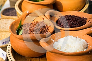 Clay pot filled with white rice, red rice and riceberry