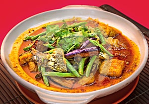 Clay pot Garoupa Fish Head Curry with long bean, eggplant and tofu on top photo