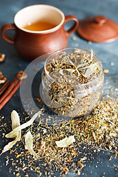 Clay pot with honey, cinnamon sticks, nuts and a herb collection