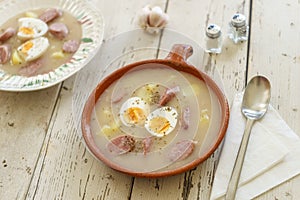 Clay pot and plate of traditional polish soup called Zurek