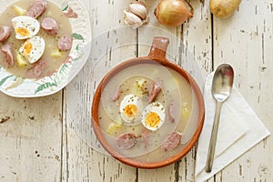 Clay pot and plate of traditional polish soup called Zurek