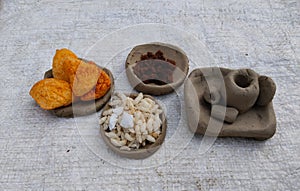 clay pot with snackes or food. Tiny clay kitchen set. Kids' toys are made of clay. Making small toys with soil for playing.