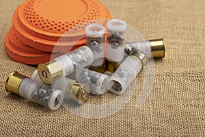 Clay shooting target with shotgun shell on sackcloth background , Clay pigeon shooting game