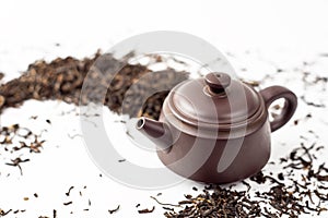 Clay tea pot and black tea on white background close up, Chinese tea ceremony