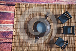 Clay teapot with chairs on a stand photo