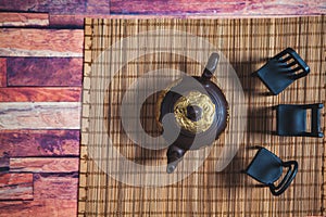 Clay teapot with chairs on a stand photo