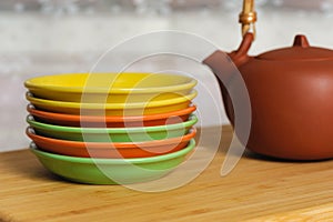 Clay teapot and color plates on a table