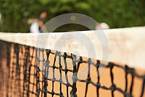 Clay tennis court with net, close up