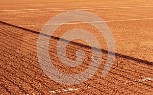Clay tennis court with a net shadow on it. Outdoor red tennis court. Background, texture, space for text