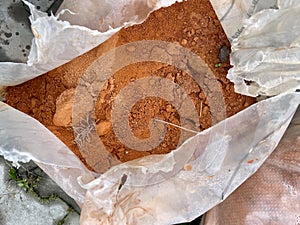 Clay for tennis court stored in a bag or sack ready to be spilled.