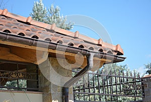 Clay tiles roof with plastic roof guter. Guttering photo