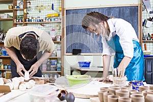 Claymaking Process Concept. Two Professional Ceramists During a Process of Clay Preparation on Tables in Workshop