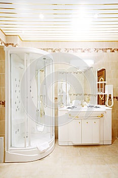 Clean bathroom with shower cabin and sink with mirror