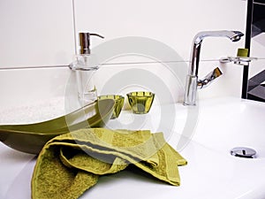 Clean bathroom sink with green towel