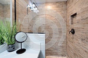 Clean bathroom with tile shower and white counter top