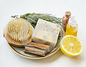 Clean beauty. Natural spa products with rosemary herb, lemon, oil bottle,natural cinnamon soap and brush, natural home skincare