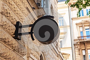 Clean black circle logo sign stands in a modern city street