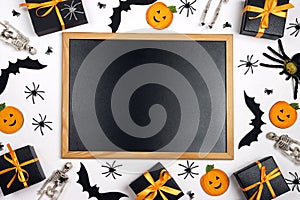 Clean blackboard with Halloween decorations on white table.  Halloween holiday background
