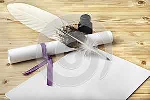 A clean of blank paper, a scroll, a goose feather, and a black ink bottle are located on a wooden table.