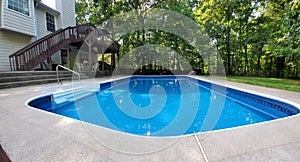 Clean blue backyard swimming pool with abstract prospective on a clear summer day