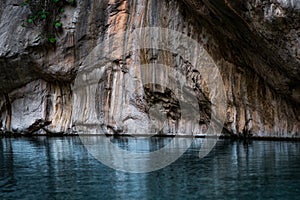 Clean blue river with rocky banks at the bottom of a deep canyon