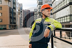 A clean builder shows sincere emotions of indignation. Man in special clothes and helmet shows hostility