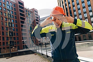 A clean builder shows sincere emotions of indignation. Man in special clothes and helmet shows hostility