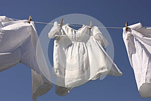 Clean clothes hanging on washing line against sky, low angle view. Drying laundry