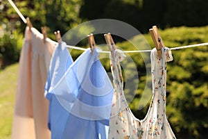 Clean clothes hanging on washing line in garden. Drying laundry