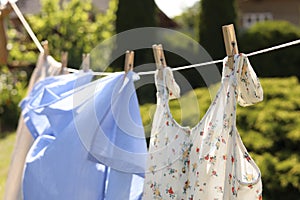 Clean clothes hanging on washing line in garden. Drying laundry