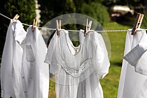 Clean clothes hanging on washing line in garden. Drying laundry