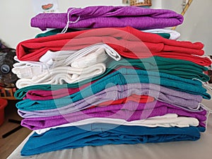 Clean, colorful cloths that have been ironed are neatly arranged on the table