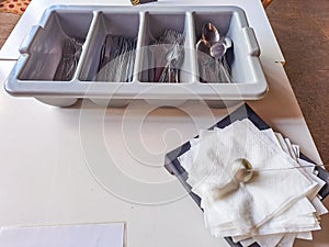 clean cutlery in a cutlery box with knives, forks, spoons in a canteen.