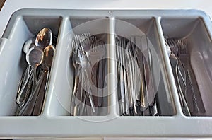 clean cutlery in a cutlery box with knives, forks, spoons in a canteen.