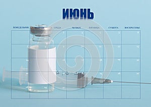 Clean desktop calendar for the month of June. The layout used as the schedule planner. Ampoule, and medical syringe in the