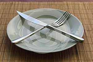 White empty plate, fork and knife on the table photo