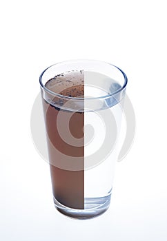 Clean and dirty water in one glass isolated on whi