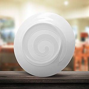 Clean dish or ceramic plate on modern kitchen background with blank dishware concept. White dish template place on wooden table