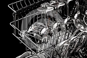 Clean dishes in the dishwasher. Wine glasses, sparkling wine glasses. Close-up. Washing-up and housework concept