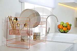 Clean dishes on drying rack in kitchen interior