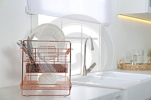 Clean dishes on drying rack in kitchen interior